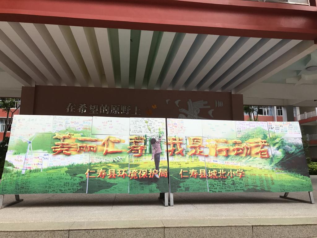 学生们“美丽仁寿,我是行动者”主题宣传海报上签名承诺